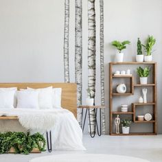 a bedroom with white walls and trees in the background