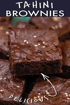 chocolate brownies with sesame seeds are stacked on a blue and green plate, ready to be eaten