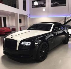 a black and white rolls royce parked in a showroom