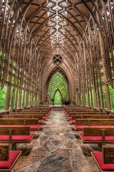 the inside of a church with rows of pews and red seats on each side