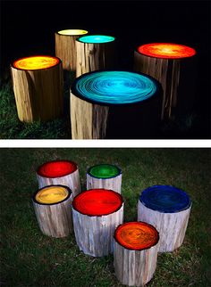 several different colored lights on wooden stumps in the grass