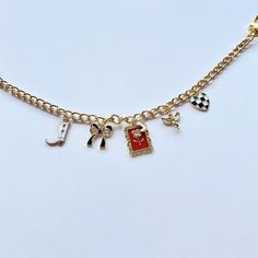 a gold chain bracelet with charms on it and an anchor, cross, heart, horseshoe, letter j