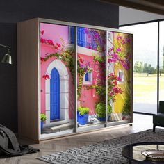 a living room with an open sliding glass door that has colorful flowers on the outside