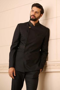 Black bandhgala in a premium suiting fabric featuring an overlapping front panel and novelty buttons, with a textured collar. Comes with a cotton-satin formal shirt and Jodhpuri trouser.
Components: 3
Pattern: Textured
Type Of Work: Linear Patterns
Neckline: Stand Collar
Sleeve Type: Straight Full
Fabric: Bandhgala : Suiting Fabric, Shirt : Cotton Satin, Trousers : Suiting Fabric
Color: Black
Other Details: 
Linear pattern textures
Overlapped panel
Novelty buttons
Occasion: 
Cocktail and Recepti Bridal Expo, Fabric Textured, Dress Suits For Men, Novelty Buttons, Suiting Fabric, Tarun Tahiliani, Linear Pattern, Formal Shirts, Dress Suits