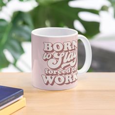 a pink coffee mug with the words born to play forced to work printed on it