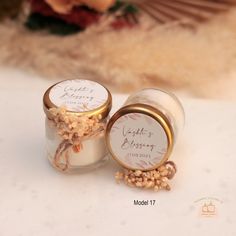 two small jars filled with wedding favors sitting on a table