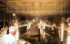 the bride and groom are walking down the aisle with sparklers