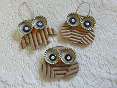 three owl ornaments are sitting on a lace tablecloth, one is made out of cardboard and the other has buttons