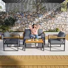 a woman sitting on top of a couch next to two chairs and a coffee table