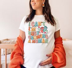 a pregnant woman wearing an i can't i'm busy growing a human shirt