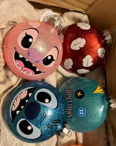 three christmas ornaments are sitting in a box