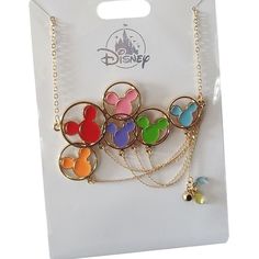 the disney mickey mouse necklace is on display in a plastic card board box with gold chain