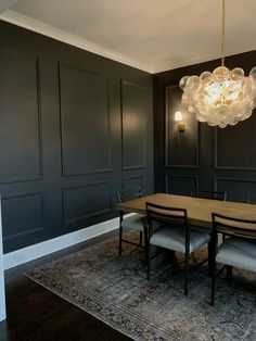 a dining room table with chairs and a chandelier hanging from the ceiling