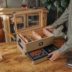 a man is opening the contents of an open briefcase on a table in front of him