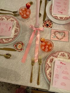 the table is set with pink and white plates