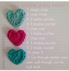 three crocheted hearts sitting on top of a piece of paper with instructions for how to crochet a tiny heart