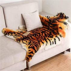 a white couch with a tiger print blanket on it