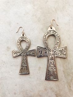 two earrings with an egyptian cross on them