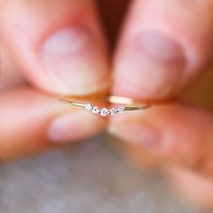 a person holding a tiny diamond ring in their hand