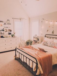 a bed room with a neatly made bed and lots of lights on the wall above it