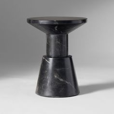 a black marble pedestal with a circular top