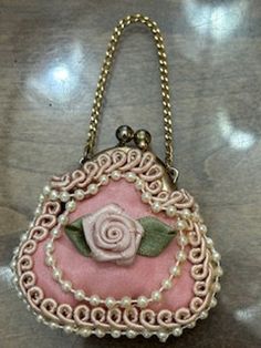 Very nice vintage Pink Rose small jeweled and silk lined ring/jewelry purse. Clasp snap small jewelry purse. Measure 2'' tall by 2 and 1/2'' wide. Pink rose with lace and pearl trim. Would be a very nice purse for a ring bearer to carry at wedding events.  Nice addition to the vintage and antique jewelry collection, vintage small jewelry purse collection, Weddings, valuable large coin or 2,  etc Thanks for viewing this very cute small jewelry purse and my shop. This small decorative ring purse w Small Pink Elegant Bag, Small Elegant Pink Bag, Vintage Pink Coin Purse As Gift, Pink Vintage Style Coin Purse Gift, Pink Feminine Evening Bag For Gift, Pink Feminine Evening Bag As Gift, Feminine Pink Evening Bag For Gift, Feminine Pink Evening Bag As Gift, Vintage Pink Bags For Weddings