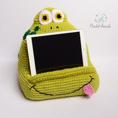 a green knitted bag with an electronic device in the shape of a smiling frog