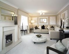 a living room filled with furniture and a fire place under a mirror on the wall