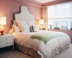 a bedroom with pink walls and white bedding