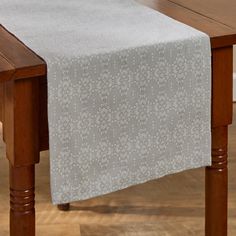 a white table runner on top of a wooden table