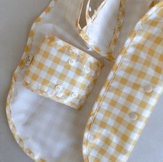 a yellow and white checkered shirt laying on top of a table next to a pair of scissors