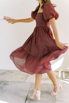 a woman in a red dress is dancing