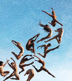 a group of people that are jumping in the air with their hands up and legs apart