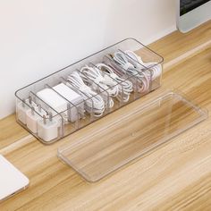 an acrylic charging station on a desk with various cords and plugs in it