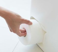 a hand is pulling a roll of toilet paper out of the bathroom wall with it's handle