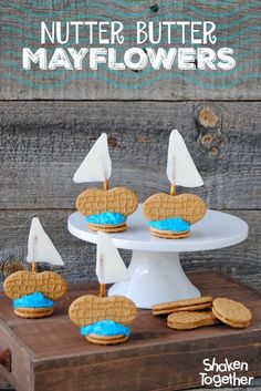 cookies and waffles are arranged on a cake stand with blue icing in the shape of boats