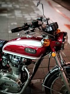 a red and white yamaha motorcycle parked on the street