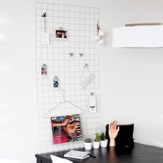 a black desk with white tiles on the wall and pictures hanging on it's side