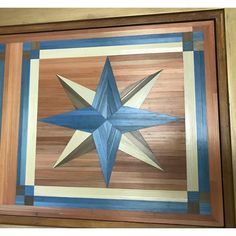 a wooden wall hanging with a blue and white star painted on the inside of it