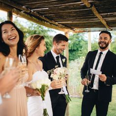 a group of people standing next to each other holding wine glasses