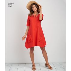 a woman in a red dress and hat poses for the camera with her hand on her head