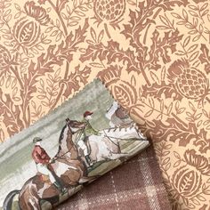 two pieces of fabric with horses and jockeys on them are laying next to each other