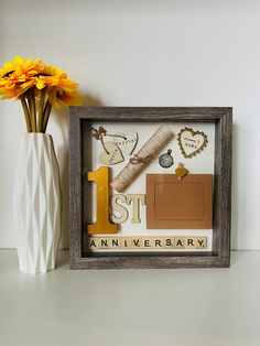 a wooden frame with some flowers in it and a vase filled with yellow daisies