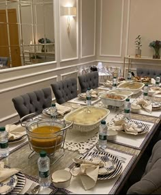 a long table is set with dishes and glasses for people to sit down at it