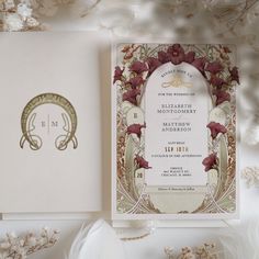 an elegant wedding card with flowers on it and a monogrammed design in the middle