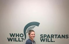 a man standing in front of a wall that says who? spartans will