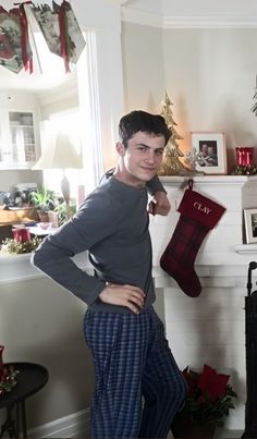 a man standing in front of a fireplace with his hands on his hips while wearing pajamas