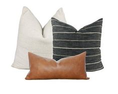 three pillows with different colors and patterns on them, one is black, the other is white