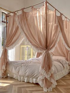 the canopy bed is made up with pink drapes and ruffled bedspreads