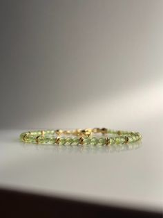 🌟 OUR SPARKLING ROYAL PERIDOT BRACELET 🌟 HANDMADE WITH LOVE The small, faceted peridot beads represent the fresh, green nuances of this fascinating gemstone. Peridot represents growth, renewal and spiritual clarity. Each bead radiates a refreshing and invigorating energy. The ornate gold beads add a luxurious touch to the bracelet. The gold beads and clasp are plated with 18k gold to ensure durability and elegance. WHY OUR ROYAL PERIDOT BRACELET? ✨ Unique, delicate design of the highest qualit Peridot Bracelet, Delicate Design, Fresh Green, Bracelet Handmade, Faceted Bead, Gold Beads, Spacer Beads, Handmade Bracelets, 18k Gold